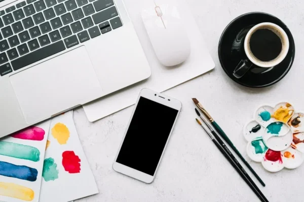 A sleek modern office setup featuring dual monitors, Apple devices, and creative decor in an indoor workspace.
